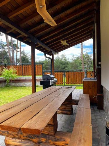 a large wooden picnic table on a patio at Rodopi Guest House in Tsigov Chark