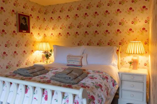 a bedroom with a bed with two lamps and towels on it at The Manners Sleeps 20 Private Bar Dining in Croxton Kerrial