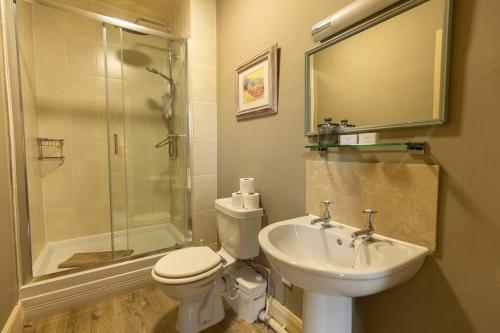 a bathroom with a sink and a toilet and a shower at The Manners Sleeps 20 Private Bar Dining in Croxton Kerrial