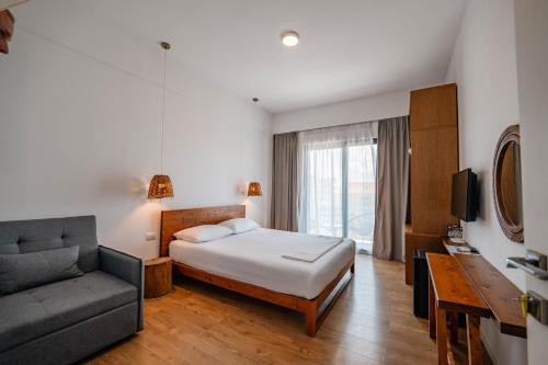 a hotel room with a bed and a couch at Kanes Boutique Hotel in Sarandë
