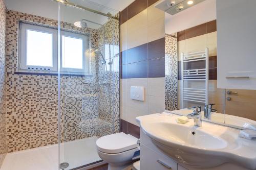 a bathroom with a sink and a toilet and a shower at Villa Klen for 15 people near Pula with jacuzzi and children playgorund in Pula
