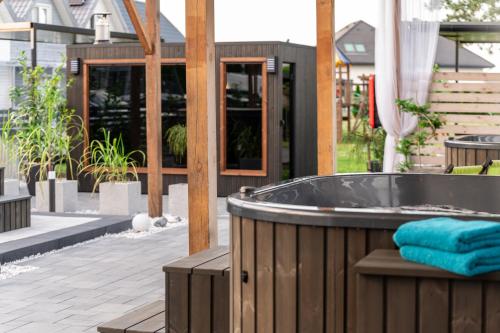 a jacuzzi tub on a patio with a house at Old Tree Villa & Restaurant in Oświęcim