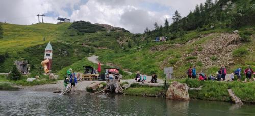 a group of people walking around a river near a hill at Sonnleitn AlpinWell Appartment (Ski in&out + Wellness) in Hermagor