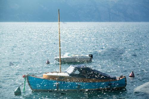 a blue boat in the middle of a large body of water at Hotel Vega in Malcesine