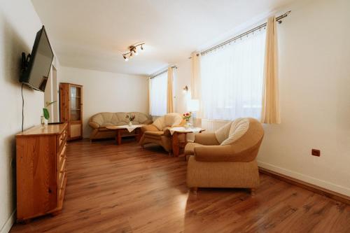 a living room with chairs and a tv and a couch at Horský hotel Bartoška in Turčianske Teplice