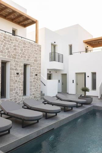 a pool with chaise lounge chairs next to a building at Kalea Suites in Pollonia