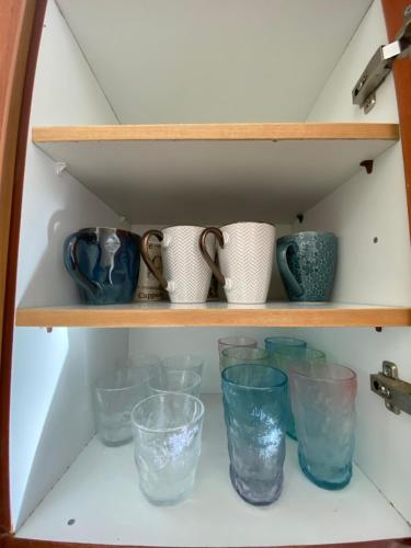 a shelf filled with glass cups and bowls at Violeta in Agios Kirykos