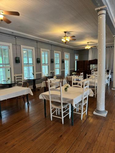 a dining room with white tables and white chairs at The Balsam Mountain Inn in Sylva