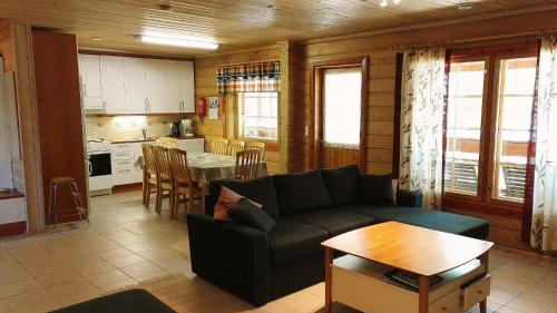 ein Wohnzimmer mit Sofa und Tisch in der Unterkunft Lomavouti Cottages in Savonranta