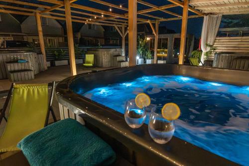 a hot tub with three wine glasses in it at Old Tree Home & Restaurant in Oświęcim