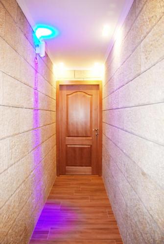 a hallway with a door and purple lights at City Apartments in Eilat