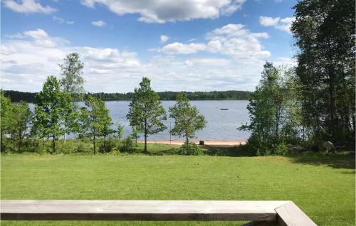 a picnic table in a park with a view of a lake at Holiday Home Mörtekull Torup in Torup