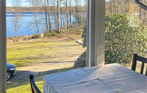 a table and a window with a view of a lake at Holiday Home Mörtekull Torup in Torup