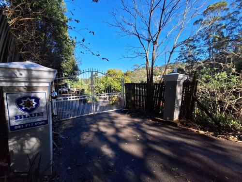 a gate with a blue sign in front of a fence at One on Old Main in Hillcrest