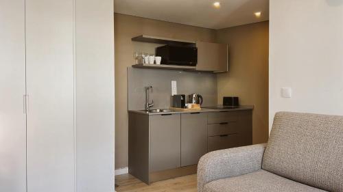 a living room with a couch and a kitchen at Lisbon Oriente Suites by Olala Homes in Lisbon