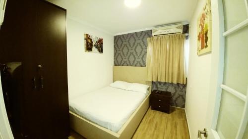 a small bedroom with a bed and a window at City Apartments in Eilat