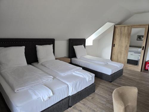 a bedroom with two beds and a mirror at Pension Nicole in Bad Bevensen