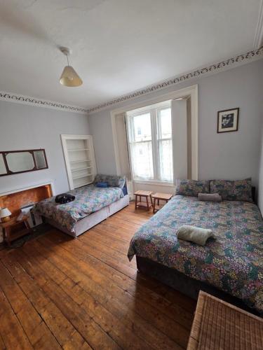a bedroom with two beds and a wooden floor at City centre Flat - sleep upto 4 in Edinburgh