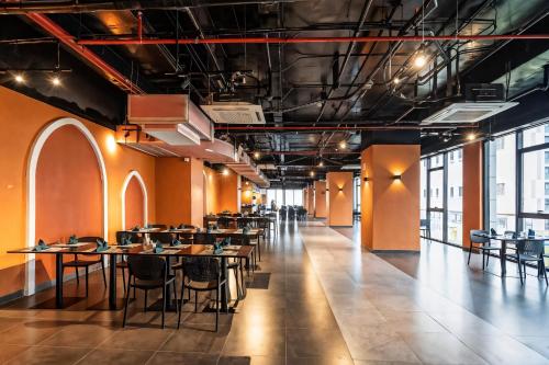a dining room with tables and chairs and windows at Golden Sands Bayfront Mũi Né in Mui Ne