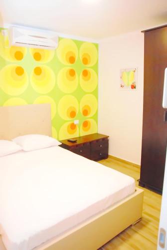 a bedroom with a bed and a green and yellow wall at City Apartments in Eilat