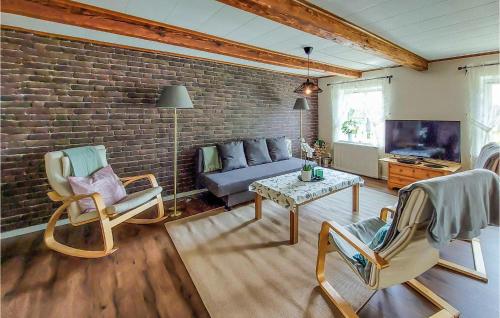 a living room with a couch and a brick wall at 2 Bedroom Cozy Home In Munka-Ljungby in Munka-Ljungby