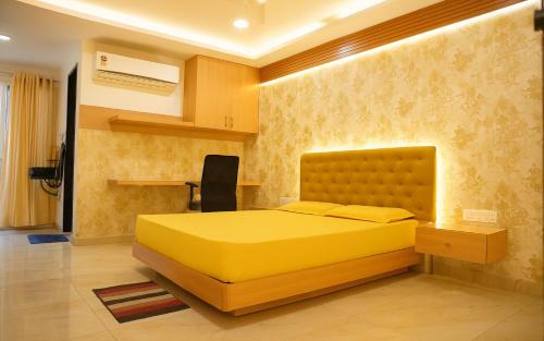 a bedroom with a yellow bed in a room at Narenn inn studio in Hyderabad