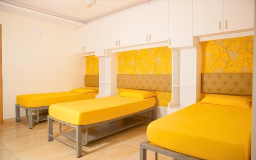 a row of yellow beds in a room at Narenn inn studio in Hyderabad
