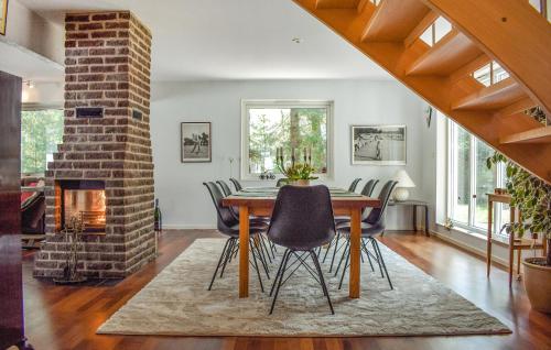 a dining room with a brick fireplace and a table and chairs at Amazing Home In Höllviken With Wifi in Höllviken