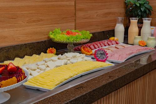 un buffet con diversi tipi di formaggi e altri prodotti alimentari di Hotel Laghetto Toscana a Gramado