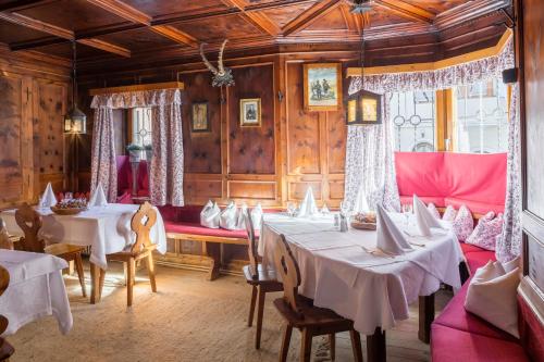 a dining room with tables and chairs and wooden walls at Isserwirt in Innsbruck
