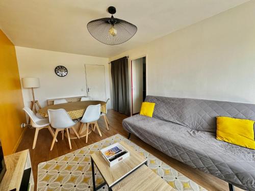 un salon avec un canapé et une table dans l'établissement Capucine, duplex à 5 min plage, à Courseulles-sur-Mer