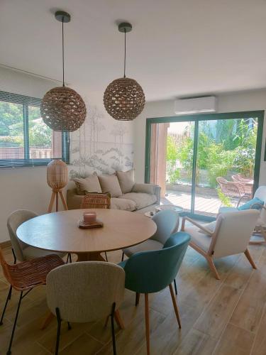 un salon avec une table et des chaises dans l'établissement Les Villas de Julie à la Maison de la Dune, à Lacanau