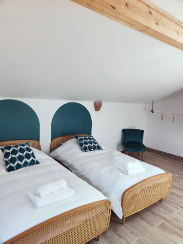 deux lits côte à côte dans une pièce dans l'établissement Les Villas de Julie à la Maison de la Dune, à Lacanau