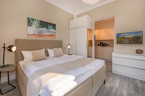 a bedroom with a large bed and a kitchen at Villa Carmen Sandburg in Ahlbeck