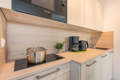 a kitchen with a stove with a pot on the counter at Villa Carmen Sandburg in Ahlbeck
