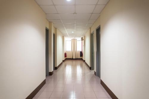 an empty hallway in an office building with white walls at Hotel O Melintang Hotel in Hutan Melintang