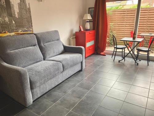a living room with a couch and a table at La petite maison rouge in Cucq