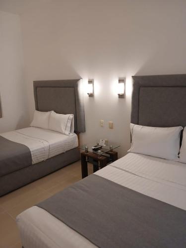 a hotel room with two beds and a side table at Zar San Luis Potosi in San Luis Potosí