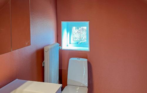 a bathroom with a toilet and a picture on the wall at 4 Bedroom Beautiful Home In Mönsterås in Mönsterås