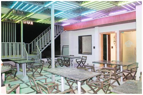 a room with tables and chairs and a staircase at Hotel Moresta Restaurant and Bar Best Facility in Ajmer