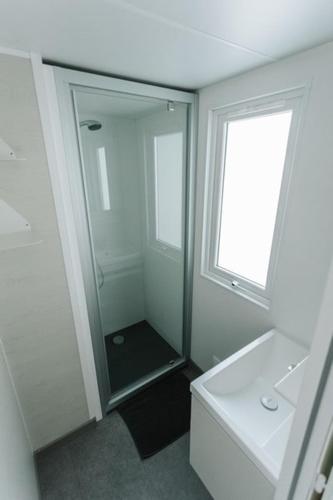 a bathroom with a shower and a sink and a mirror at Camping Le Littoral in Le Grau-dʼAgde