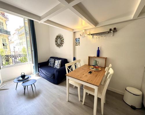 un salon avec une table et un canapé bleu dans l'établissement ApartHotel Riviera - Duplex de la Buffa - 100m promenade des Anglais, à Nice