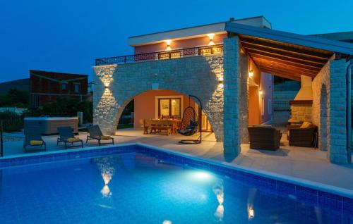 a villa with a swimming pool at night at Holiday home Villa Vrbnik by Villas guide in Vrbnik