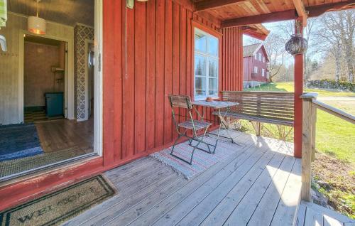 a porch of a red house with a table and chair at Lovely Home In Hindås With Kitchen in Hindås