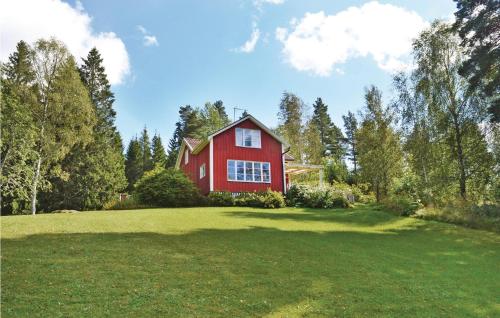 a red house on top of a green field at 3 Bedroom Cozy Home In Åmål in Åmål