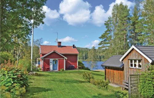a red cottage with a yard and a lake at 3 Bedroom Cozy Home In Åmål in Åmål