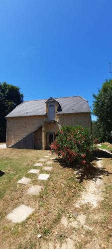 a building with a roof on a field with flowers at La cachette en Bouriane in Saint-Cirq-Madelon