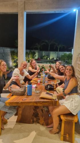 a group of people sitting around a wooden table at Jancoox Hostel in Kuta Lombok