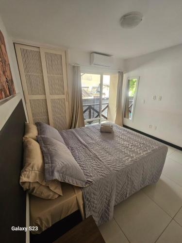 a bedroom with a bed with pillows and a window at Ecoparadise Flat 103 in Caucaia