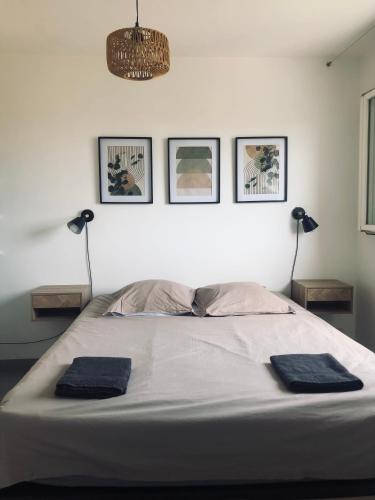 une chambre avec un lit avec deux serviettes bleues dessus dans l'établissement Lumineux avec piscine, Wifi & Terrace - Proche plage & Aéroport, à Saint-Laurent-du-Var